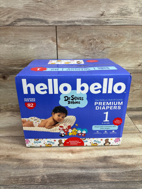 Front view of Hello Bello Premium Diapers size 1 box showcasing 82 diapers and Dr Seuss Babies design on a wood background