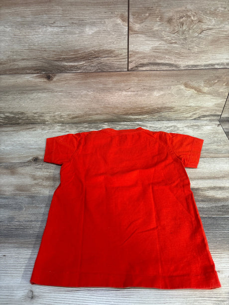 Back view of Uniqlo UT x Kaws Sesame Street Elmo toddler T-shirt showing plain red back laid flat on wood floor