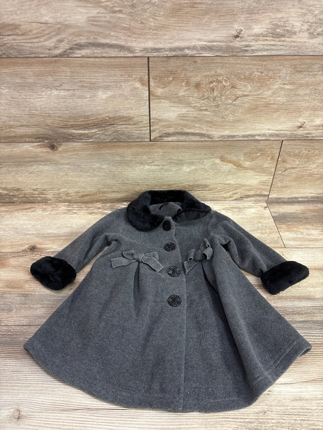 Front view of Youngsport grey fleece dress coat in size 18 months showcasing black faux fur trim, bows, and buttons on wood