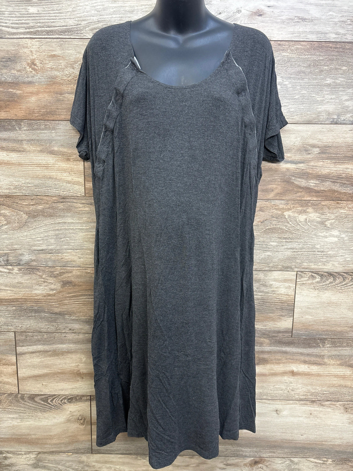 Front of charcoal grey Frida nursing gown on mannequin with scoop neck, short sleeves and side snaps, wood background