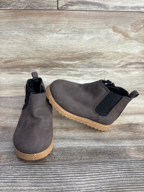 Pair of brown toddler Chelsea boots with tan speckled soles on wooden surface