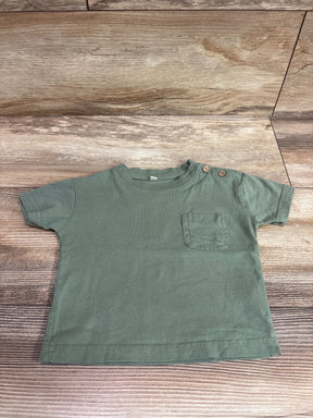 Zeeman solid green short sleeve pocket shirt for babies size 3-6m on a wood background