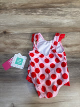Pink and red polka dot baby swimsuit with ruffles, Disney Baby tag, on wood floor