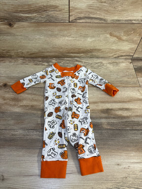 Top-down view of Magnolia Baby white footless sleeper with orange cuffs and football-themed print, front zipper on wood background