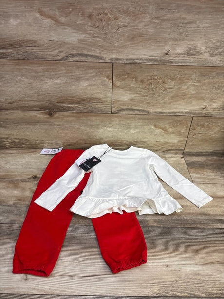 Top view of Guess peplum shirt and corduroy pants set showcasing white ruffled shirt and red pants on wood flooring