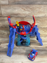 Front view of Spidey Web-Quarters playset with open red and blue hub, Spider-Man figure, and toy car on wood floor