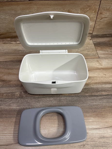 Open OXO Tot Perfect Pull Wipes Dispenser with white hinged lid and separate gray rectangular component on wood flooring