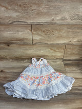 Flat-lay of Tommy Bahama tiered sleeveless dress size 12 months showing floral panels and lace on wood background
