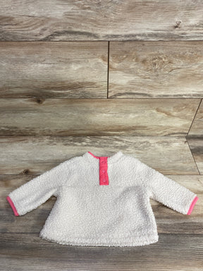 Flat lay of Baby Gap ivory sherpa henley pullover (3–6M) showing pink snap placket and pink cuff trim on wood floor