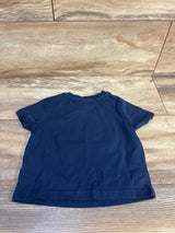 Navy blue toddler t-shirt laid flat on wood floor, kids clothing resale