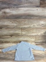 Light blue fleece kids jacket with long sleeves, laid flat on wooden floor background