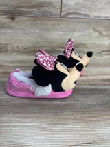 Pair of pink children's slippers featuring Minnie Mouse with polka dot bows and plush lining on wooden floor