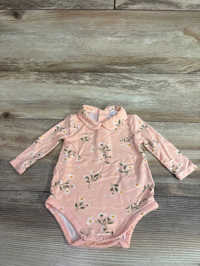 Flat lay of pink Angel Dear Peter Pan collar bodysuit showing daisy print, long sleeves, and snap crotch on wood background