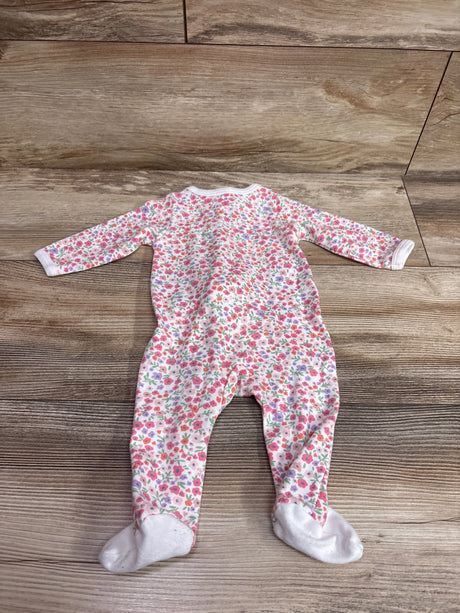 Front view of Mini Hop Sleeper in white with floral print, long sleeves, and built-in feet on a wood background