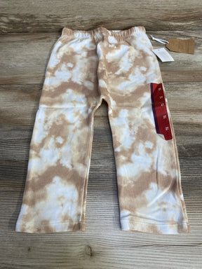 Top-down view of Grayson Collective tie-dye toddler pants, tan and white, elastic waistband, size 2T sticker on wood