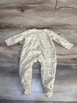 Cream baby onesie with gold sun print, long sleeves and footies, laid on wood floor