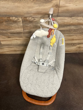 Top view of Chicco Float baby seat with light-gray quilted cover, adjustable straps, hanging cloud and sun toys, wood base