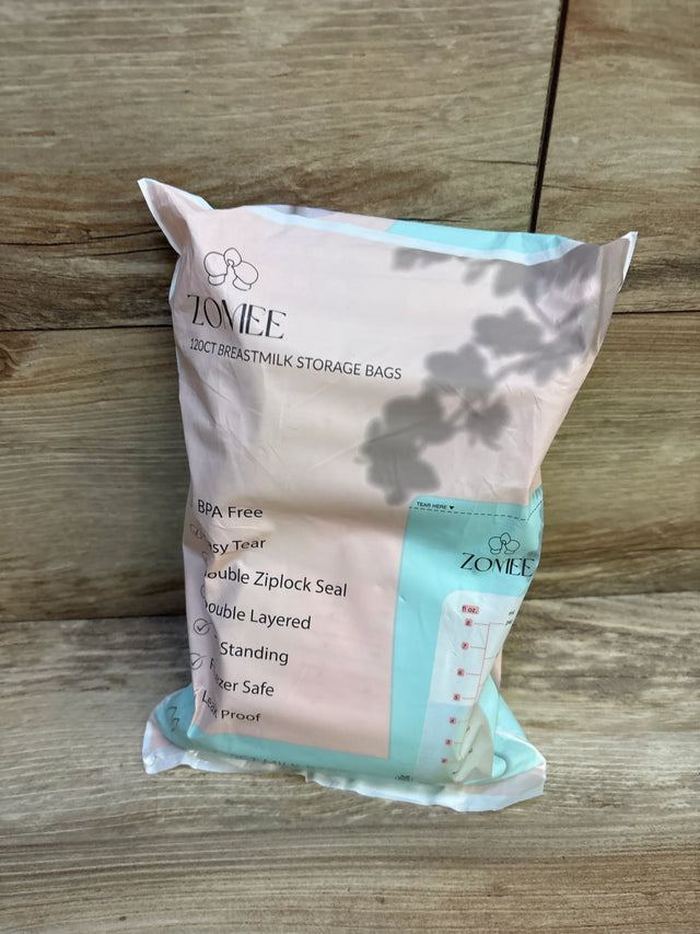 Zomee 120-count breastmilk storage bags package on wood floor, BPA free, freezer safe