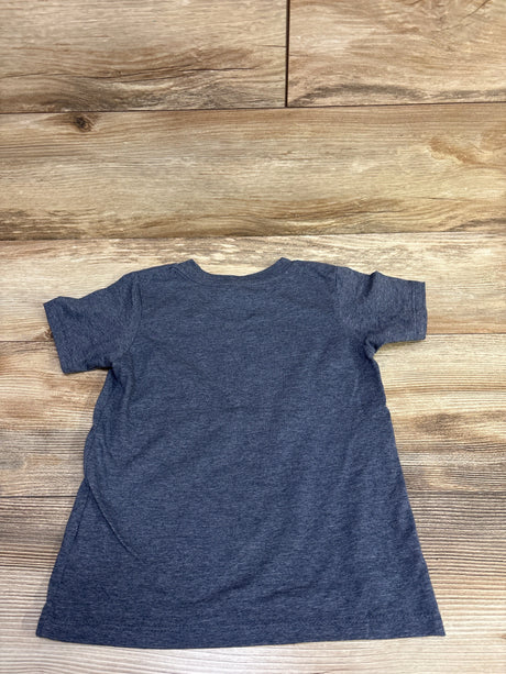 Back view of a blue short-sleeve shirt in size 4T laid flat on a wood floor