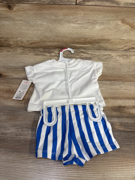 Flat lay of newborn two-piece: white short-sleeve tee and blue-and-white striped elastic-waist shorts on wood background
