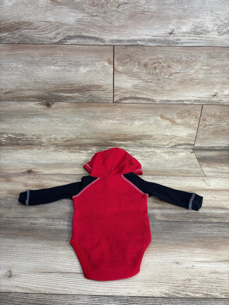 Red and black long sleeve baby bodysuit with hood on wood floor