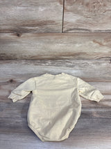 Back view flat lay of yellow bubble romper showing long sleeves and elasticized leg openings on wood background