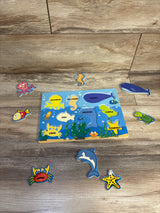 Top-down view of Educational Toys Sea Puzzle (8 pieces) with labeled blue wooden board and eight removable sea-animal pieces on wood background