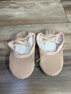 Pair of light pink toddler ballet shoes with elastic straps on wood floor
