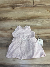 Top-down view of Cloud Island pink 2-piece baby tank dress with matching bloomers, ruffled shoulders and waist bow on light wood background