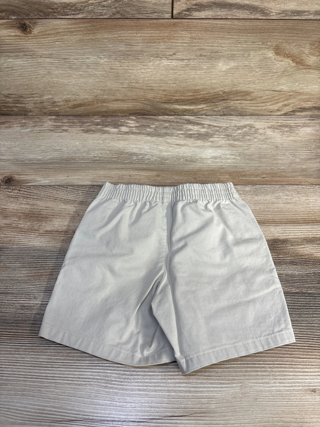 Back view of Polo Ralph Lauren khaki toddler shorts showcasing elastic waistband, size 2T, flat on wood background