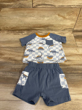 Flat lay of blue 2-piece dinosaur shirt and shorts showing checkerboard dino print, chest pocket and elastic waist on wood