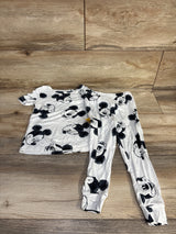 Flat lay of toddler white Disney Mickey 2-piece viscose pajama set showing black Mickey face print on wood floor