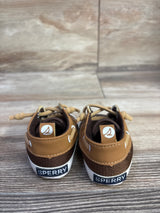 Rear view of Sperry baby boat crib shoes showcasing tan leather and brown mesh uppers with white soles on wood background
