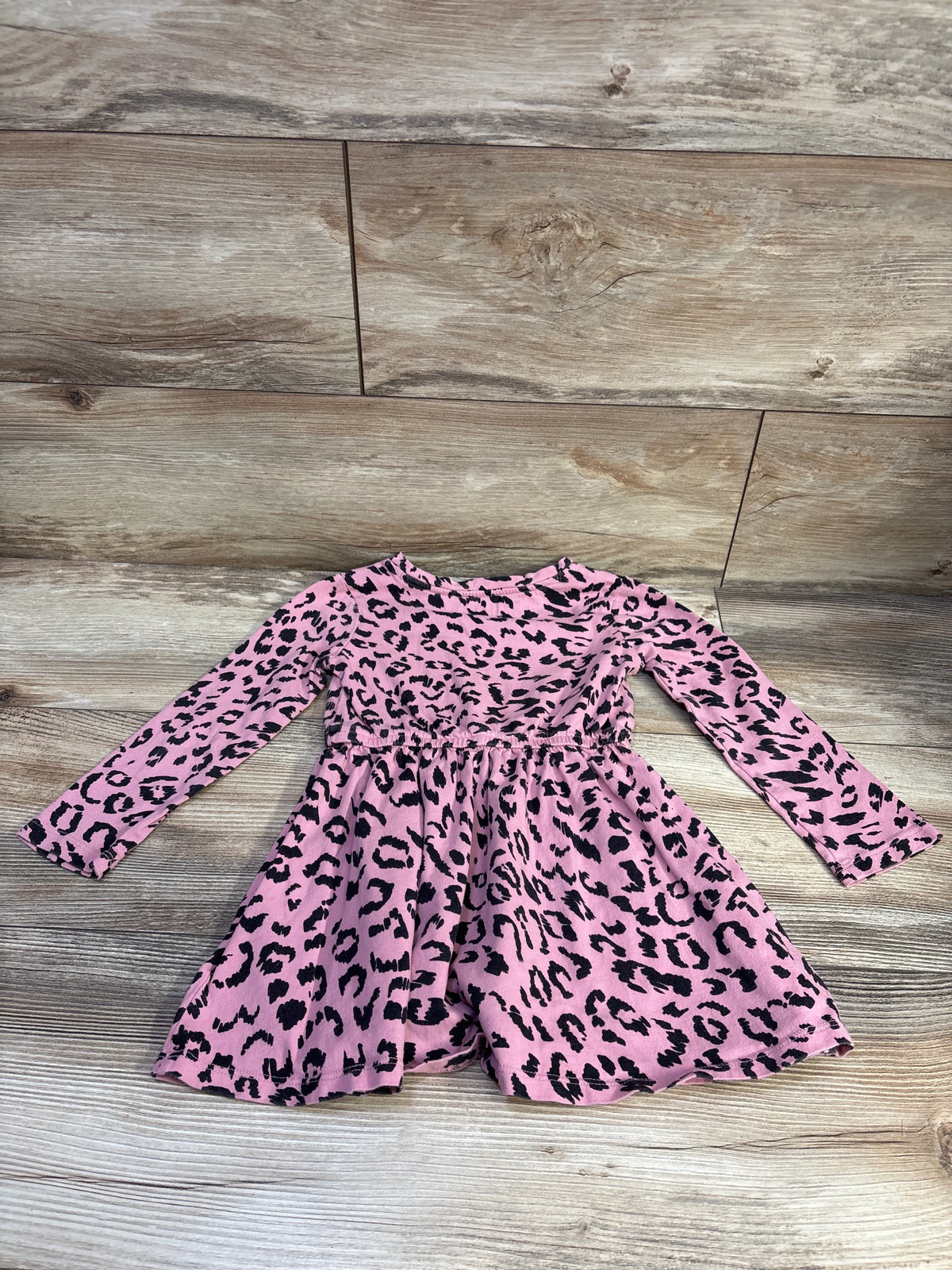Front view of Amazon Essentials pink leopard-print dress with long sleeves and gathered waist, size 4T, on wood-look floor