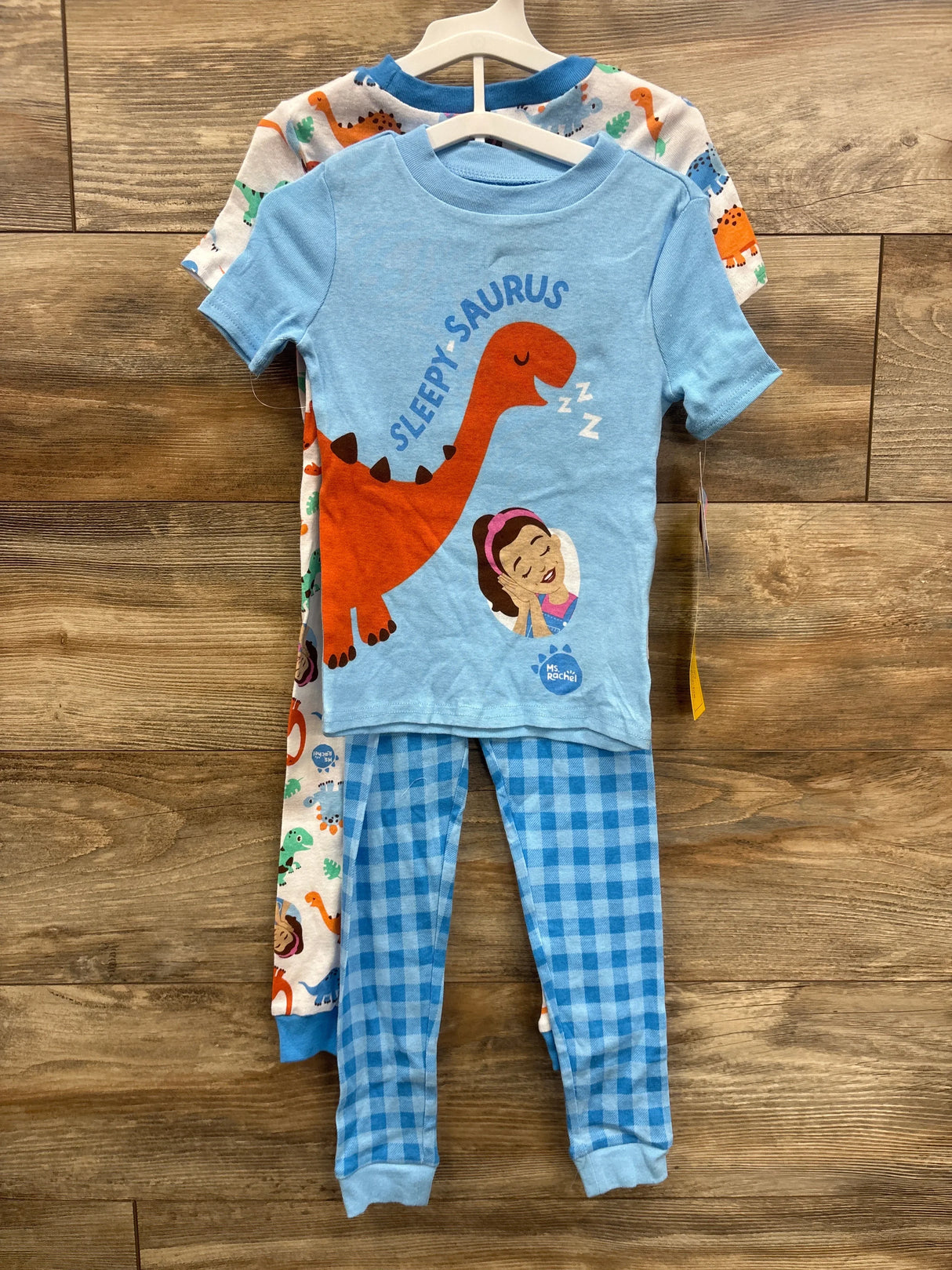 Blue dinosaur-themed kids pajamas with 'Sleepy-Saurus' print and checkered pants, perfect for toddler bedtime.