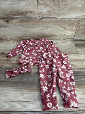 Pink floral baby outfit set with long sleeve top, pants, and matching headband on wood background