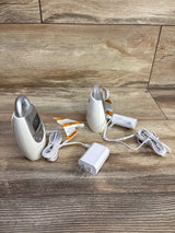 Front and side view of VTech DM221 audio baby monitor showing parent unit display, baby unit, adapter, and cords on wood background