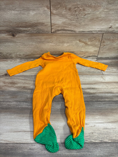 Front view of Fred and Flo Cutest Pumpkin footie showcasing orange long sleeves and green textured foot coverings on a wood floor