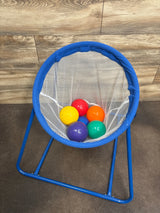 Top-down view of Lakeshore Learning ball toss set showing blue frame and white mesh hoop with six colorful balls on wood floor