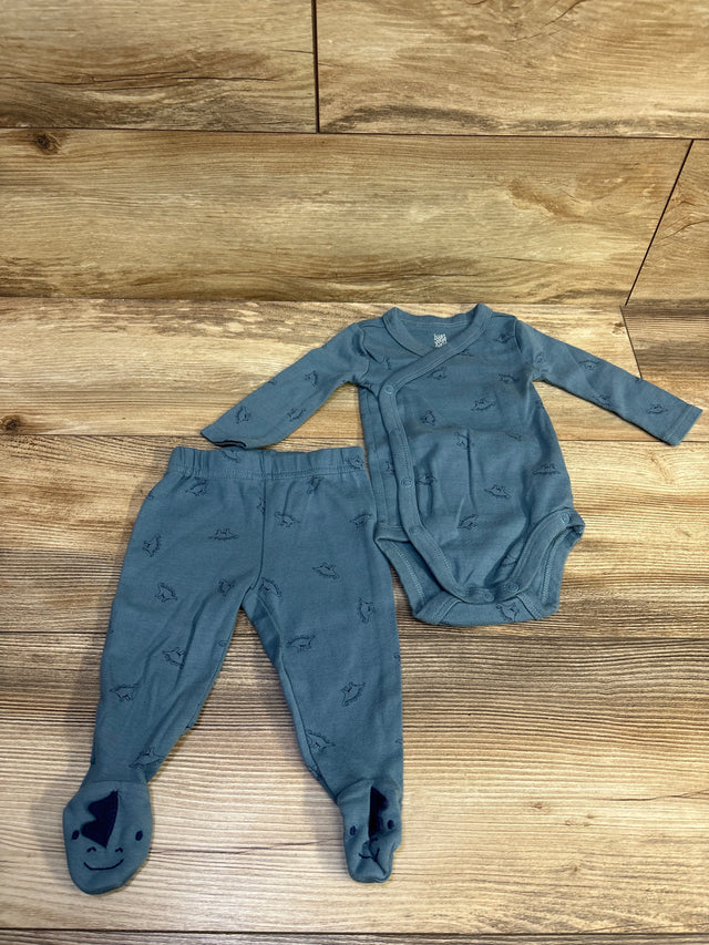 Top view of Just One You 2pc kimono bodysuit and footed pants in blue with dinosaur print on a wood surface