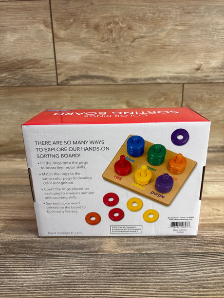 Back of Lakeshore Learn & Play Color Rings Sorting Board box showing color-coded rings and pegs on a wood floor