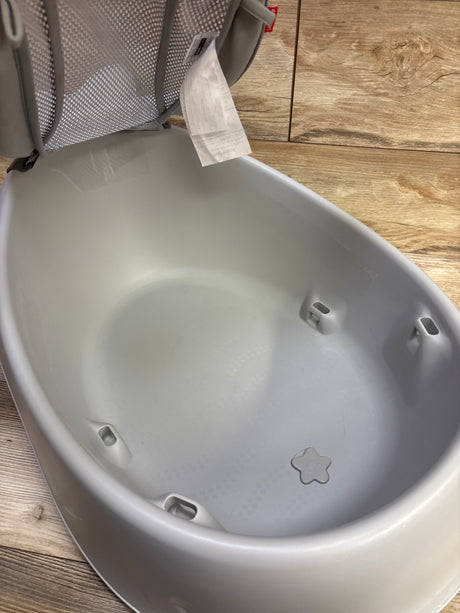 Top view of Skip Hop Moby Smart Sling 3 In 1 Baby Bathtub showcasing grey tub and mesh sling on a wood floor