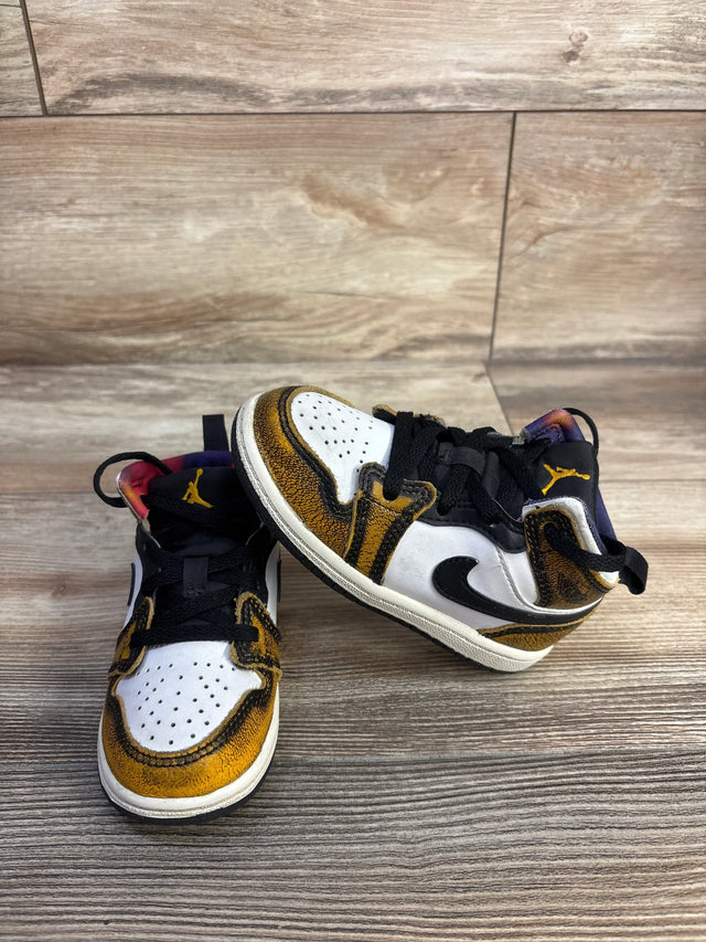 Front and side view of Air Jordan 1 Mid SE TD 'Wear-Away - Taxi' toddler sneakers showing distressed yellow overlays, black Swoosh, white toe on wood floor