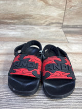 Front view of toddler red camo And1 slide sandals showing embossed AND1 logo on velcro straps on wood-look background
