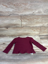 Flat lay of Old Navy burgundy waffle-knit long-sleeve toddler shirt showing scalloped hem and ribbed texture on light wood background