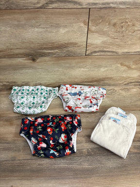 Top-down view of Rig 'N Gigs pocket cloth diapers 3-pack showing three printed covers and two absorbent inserts on wood floor