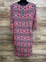 Front view of Jessica Simpson maternity dress showcasing pink and navy medallion print, front zipper and side ruching on wood backdrop