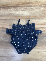 Top view of Old Navy navy baby bubble romper showcasing smocked ruffle bodice and white star print on light wood background