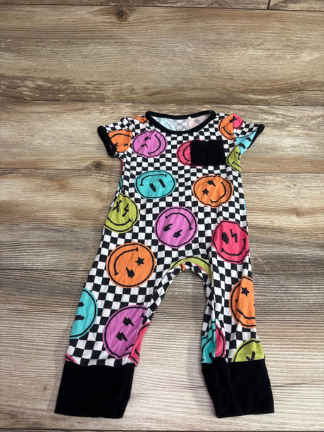 Front view of The Simple Seed bamboo day-to-night romper showcasing colorful smiley faces on a checkerboard print, laid flat on wood