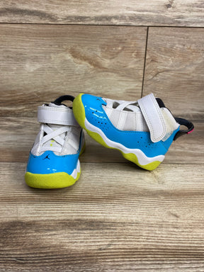Toddler athletic sneakers with blue and yellow accents on a wood background